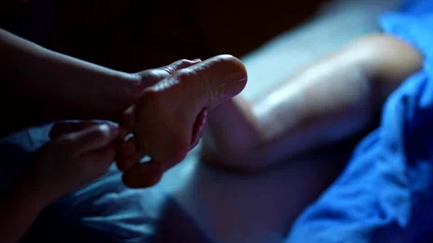 Close-up of a foot massage using oil. The warm light makes the frame cozy  Stock Footage 302171603