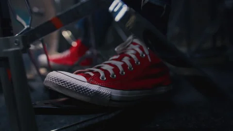Close up: foot in a red shoe presses on pedal of drums, rhythmically playing Stock Footage 329555663