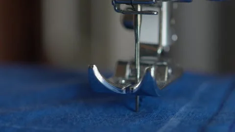 Close-up, the foot of the sewing machine presses the fabric and in slow motion Stock Footage 133429511