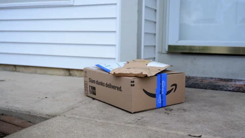 Close up footage of Amazon delivery package with padded envelopes left on a Stock Footage 330985956