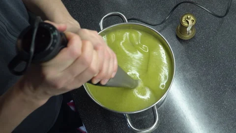Close up footage of blending process of  green vegetable cream soup in a po.. Stock Footage 303995238