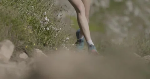Close-up footage capturing a runner’s foot striking the ground on a natural Stock Footage 321355225