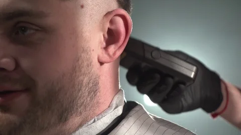 Close-up footage of client to whom a barber shaves his temple with electric Stock Footage 124711152