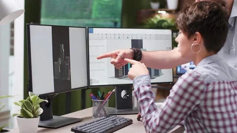 Close up footage of engineer and designer lookign together at building renders Stock Footage 110484283