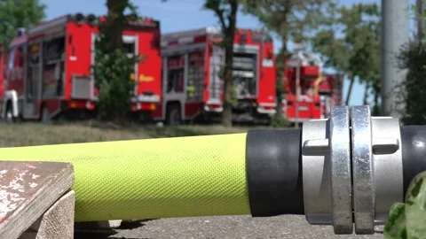 Close Up Footage of Fire Hose Coupling With Blurred Fire Trucks Stock Footage 336911769