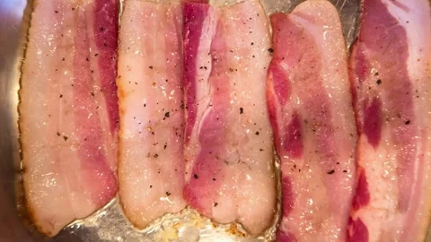 Close up footage of fresh bacon strips cooking on the stove. 스톡 동영상 334641982