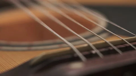 Close-up footage of guitar strings. man plays strings of yellow acoustic guitar Stock Footage 147441401