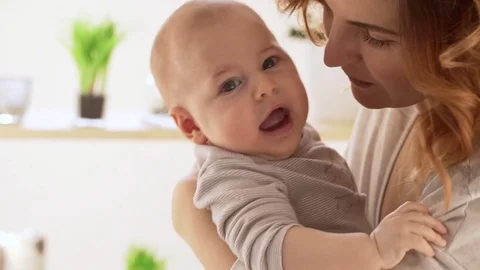 Close up footage of happy Caucasian female holding in arms her son in slowmotion Stock Footage