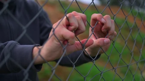Close up footage of human hands touching and pushing an iron fence. Vidéo 325741595