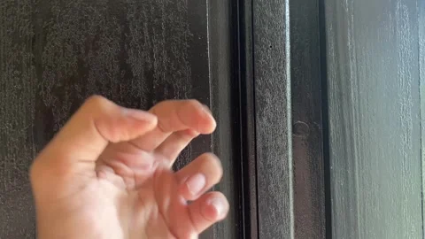 Close-up Footage of Knuckles Knocking on a Dark Black Door Stock Footage 319018921