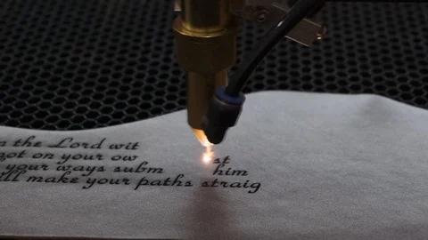 Close-up footage of laser machine engraving holy bible quote on leather sheet Stock Footage 125478041