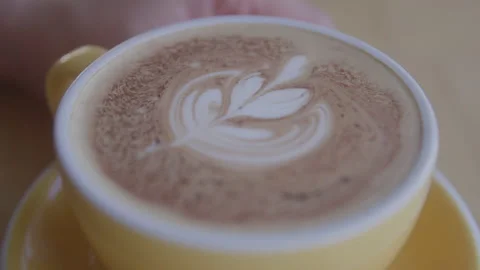 Close Footage of a Latte with Pattern in the Foam in a Yellow Cup Video stock 208800834