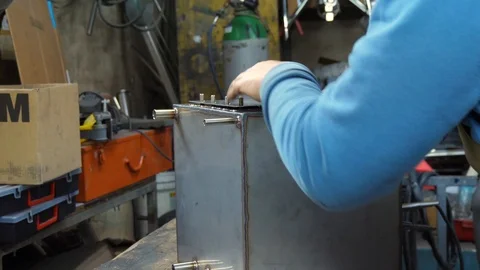 Close up footage of man assembling part of stainless steel in his garage. Stock Footage 100216420