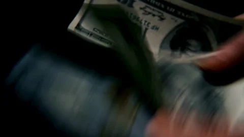 Close-up footage of a man's hand counting dollar money on a black background. Stock Footage 336260065