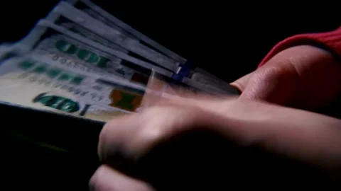 Close-up footage of a man's hand counting dollar money on a black background. Stock-Footage 336260118