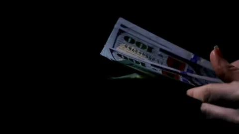 Close-up footage of a man's hand counting dollar money on a black background. Stock-Footage 336260142