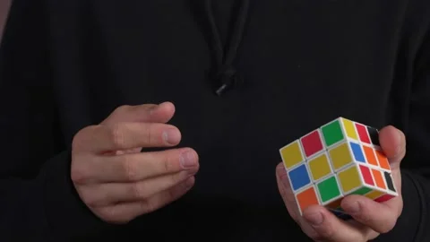 Close up footage of a man's hands solving a Rubik's cube puzzle, isolated on a Stock Footage 184595624