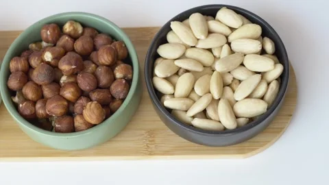 Close up footage of mixed almonds, pecans and hazelnuts arranged in bowl 库存影片 345653232