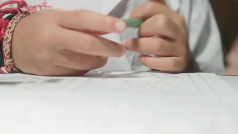 Close-up footage of a mother pointing at a worksheet while helping her chil.. Stock Footage 342216612