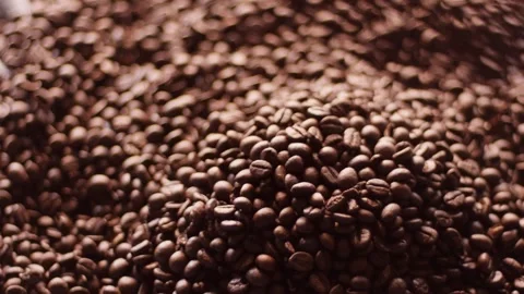Close-up footage of numerous roasted coffee beans scattered across a surface 스톡 동영상 328485948