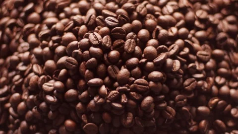 Close-up footage of numerous roasted coffee beans scattered across a surface Stock Footage 328485992