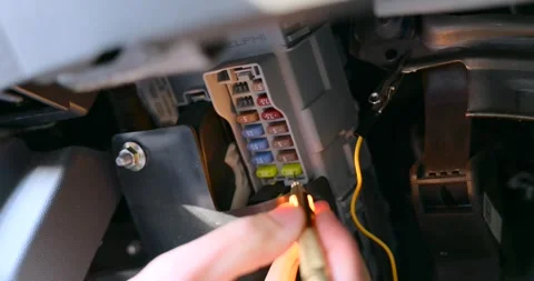 Close-up footage of a person testing a car fuse box with a voltage tester Stock Footage 310587325