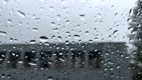 Close up footage of rain drops on a window with city buildings at the background Stock Footage 183909750