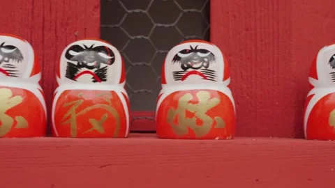 Close-up footage reveals rows of small Daruma dolls carefully arranged inside Stock Footage 344280428