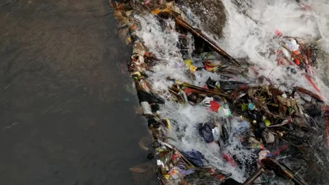 Close up footage of river current moving past plastic garbage. Stock Footage 336314241
