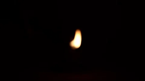 Close-up footage of a single candle flame flickering gently in darkness cre.. Stock Footage 333873026