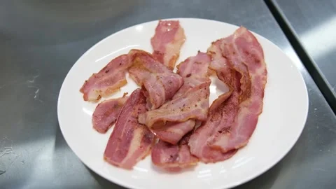 Close up footage of a slice of tasty bacon fried with oil in a cast-iron pan Stock Footage 288000053