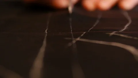 Close up footage of a tailor cutting lines on lining fabric and making some Stock Footage 127474941