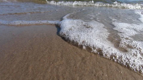 Close up footage of waves rolling in on the a sandy beach. Summertime in Sweden. Stock Footage 155409754