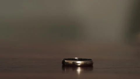 Close-up footage of a wedding ring lying on the table. Stock Footage 303926925