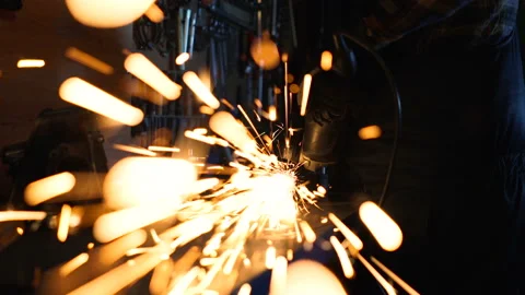 Close up footage of worker using ginder, sparks from ginder flying to the camera Stock Footage 124168070