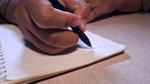 Close Up Footage Writing Notes in Notebook with Pen Warm Lighting Vídeo Stock 332893793
