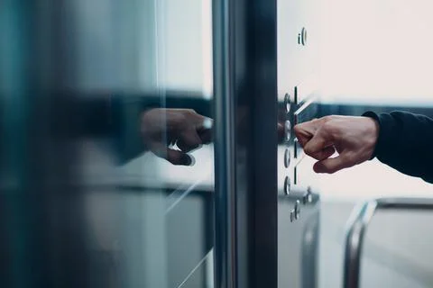 Close up of forefinger knuckle pressing the button elevator during coronavirus Foto stock
