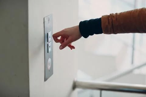 Close up of forefinger knuckle pressing the button elevator during coronavirus Foto stock