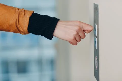 Close up of forefinger knuckle pressing the button elevator during coronavirus Foto stock