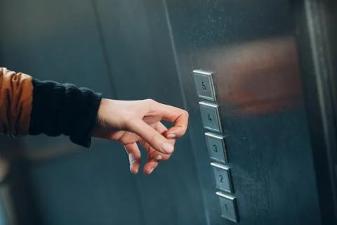 Close up of forefinger knuckle pressing the button elevator during coronavirus Foto stock