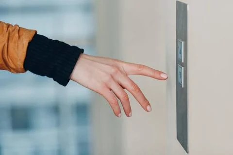 Close up of forefinger pressing the button elevator during coronavirus pan... Stockfoto's