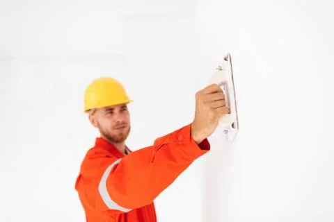 Close up foreman in orange work clothes and yellow hardhat using Stock Photos