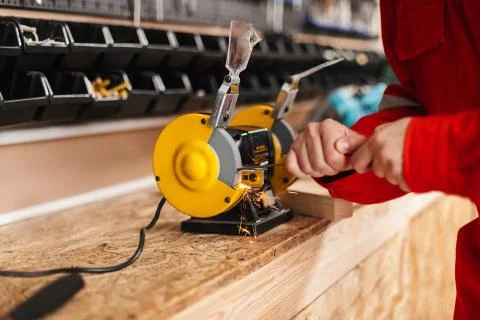 Close up foreman using yellow knife sharpener in workshop isolat Stock Photos