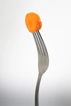 Close up of a fork with a carrot on a light gray background. Foto stock