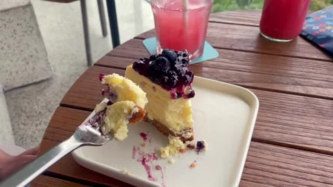 Close-up of a fork cutting into a slice of delicious blueberry cheesecake. Stock Footage 320477479