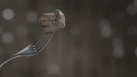 Close-up of fork with delicious grilled meat on shiny blurred background Stock Footage 143090757