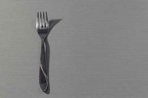 Close-up fork isolated on a light striped background. Stock Photos