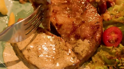 Close Up of Fork Lifting Grilled Pork Steak with Pepper Sauce Stock Footage 335851497