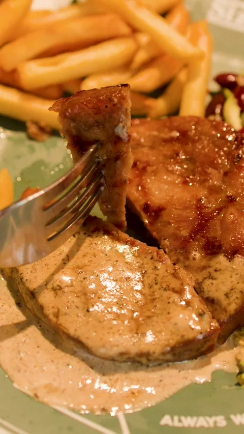Close Up of Fork Lifting Grilled Pork Steak with Pepper Sauce Stock Footage 336520058