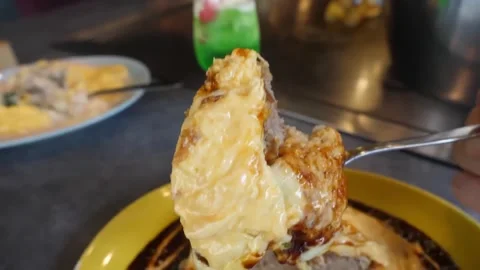 Close Up of Fork Lifting Omelet with Meat Patty and Rice Dish Stock-Footage 347688710